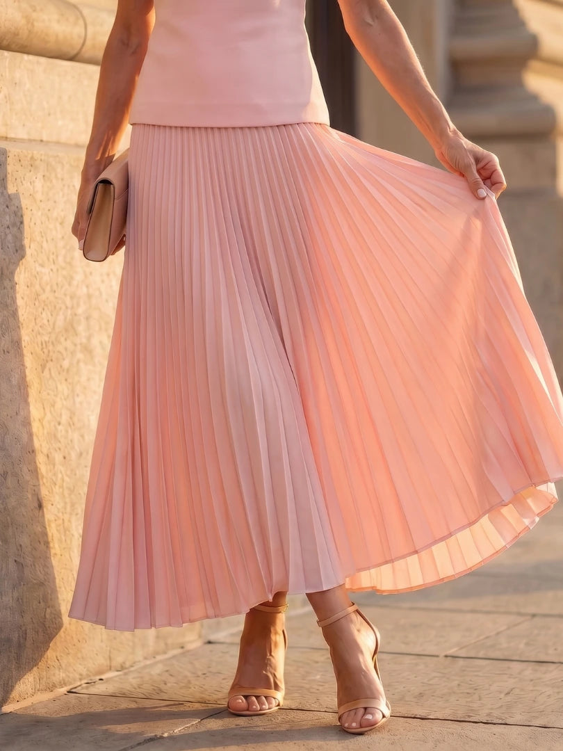 Woman wearing a pink structured bodice pleated skirt set - studio photo