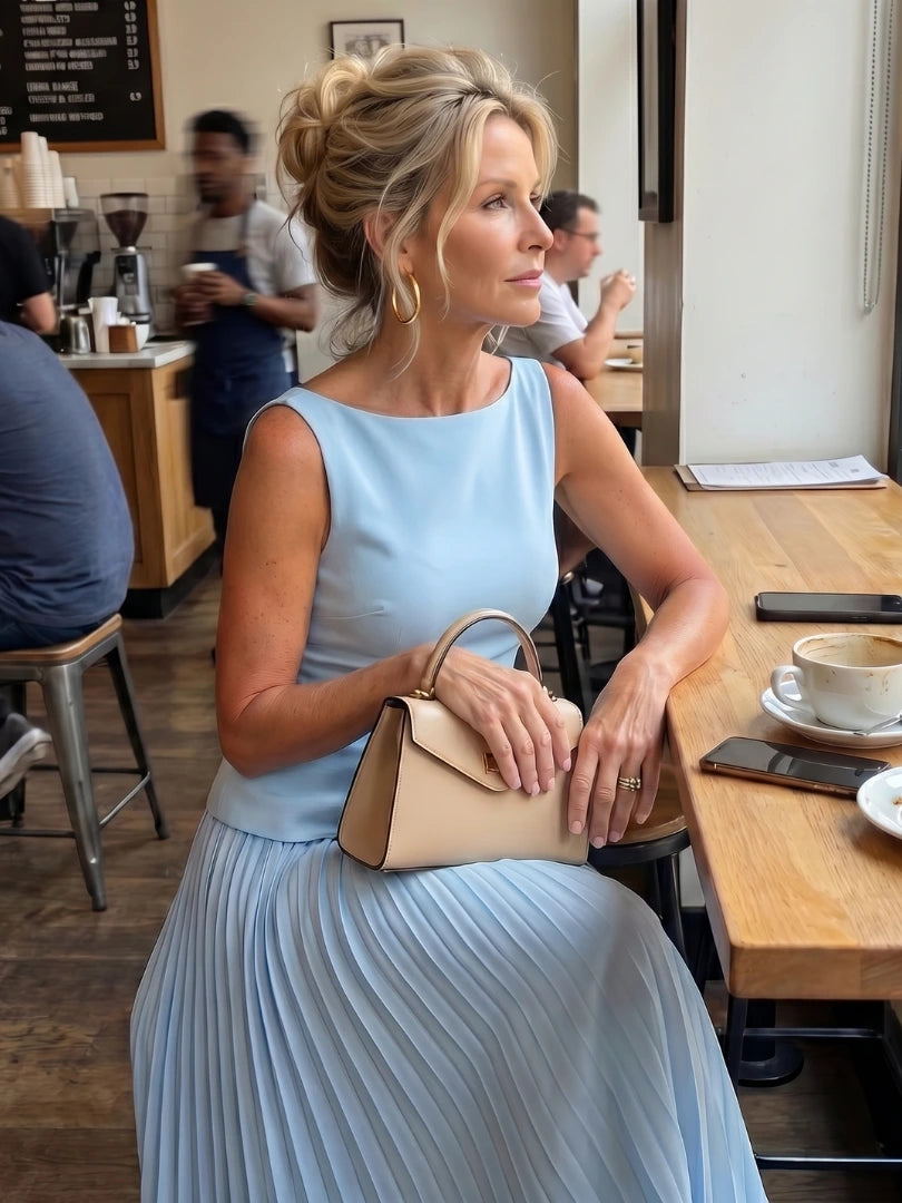Woman wearing a sky blue structured bodice pleated skirt set - editorial style photo