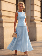 Woman wearing a sky blue structured bodice pleated skirt set - editorial style photo