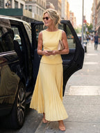 Woman wearing a yellow structured bodice pleated skirt set - editorial style photo