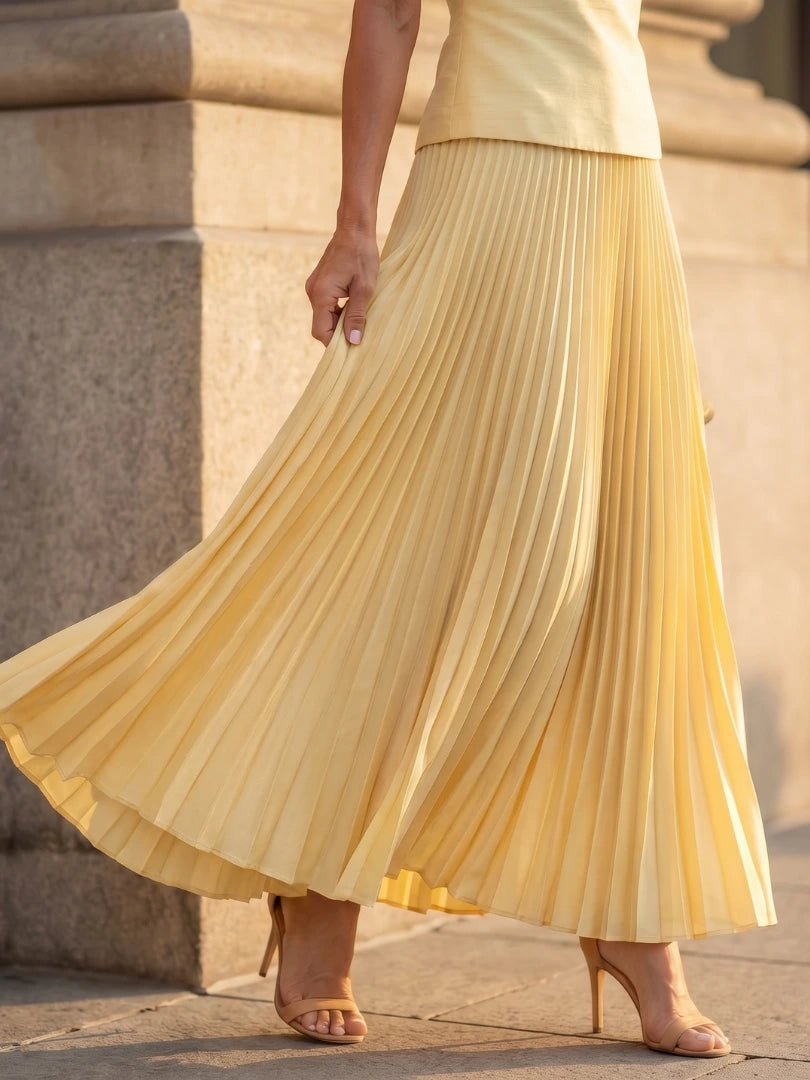 Woman wearing a yellow structured bodice pleated skirt set - studio photo