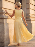 Woman wearing a yellow structured bodice pleated skirt set - studio photo