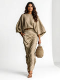 Woman wearing a khaki two-piece coordinating skirt set, studio setting