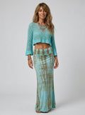 Woman wearing a teal and khaki tie-dye maxi skirt in a studio setting