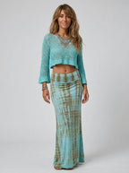 Woman wearing a teal and khaki tie-dye maxi skirt in a studio setting