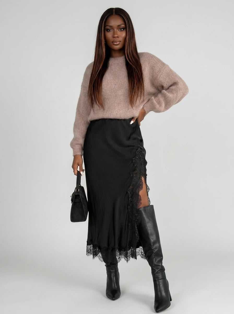 Woman wearing a black viscose satin midi skirt with lace trim in a studio setting