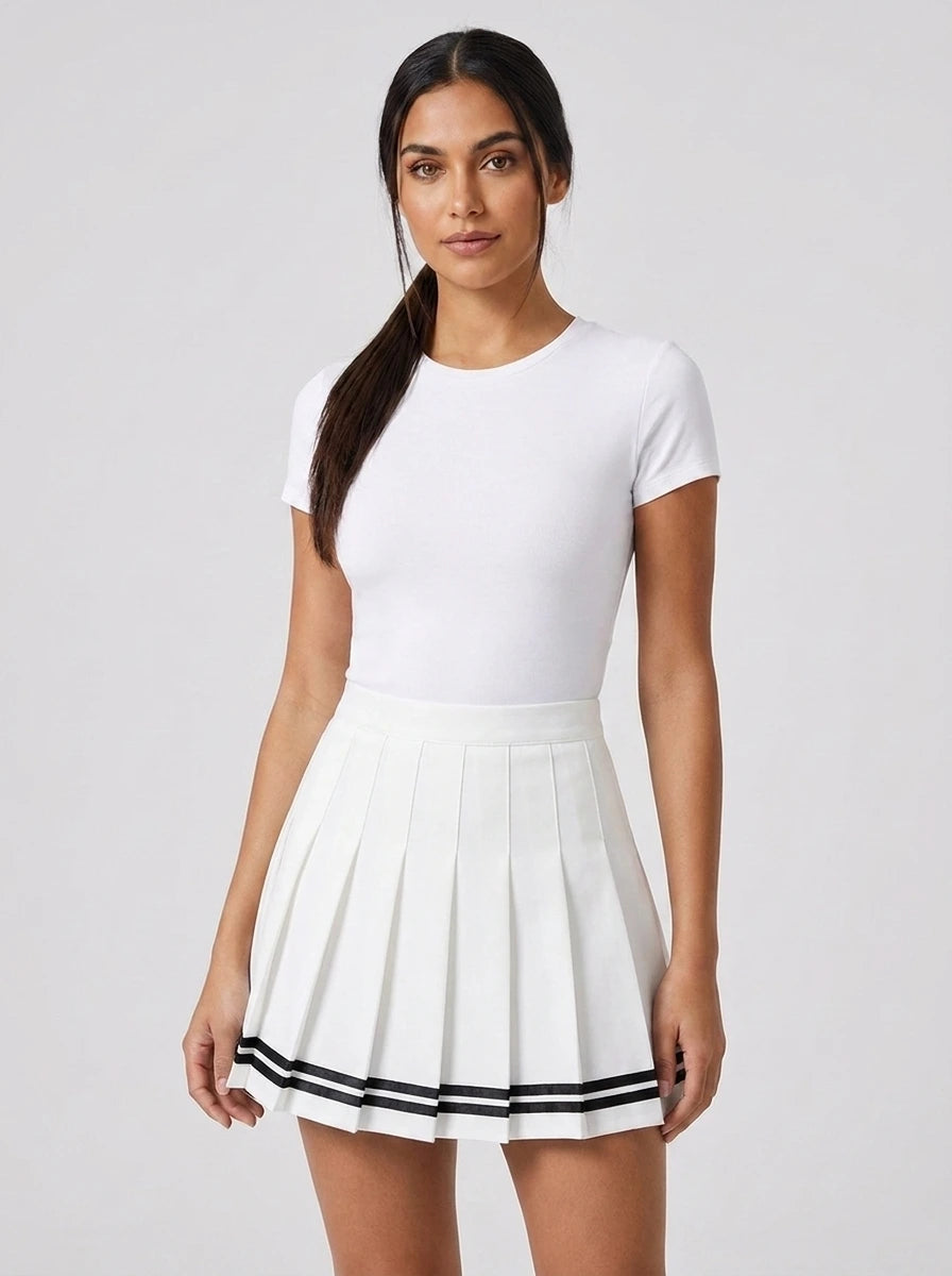 Woman wearing a white pleated mini skirt with black stripe hem in a studio setting