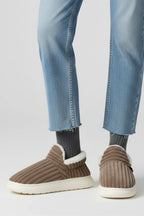 Woman wearing a brown ribbed upper faux fur lined slipper - lifestyle photo