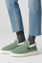 Woman wearing a green ribbed upper faux fur lined slipper - lifestyle photo