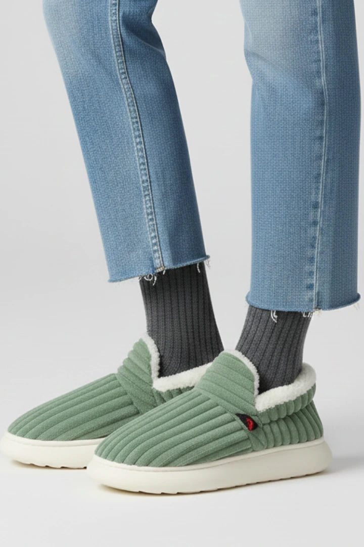 Woman wearing a green ribbed upper faux fur lined slipper - lifestyle photo