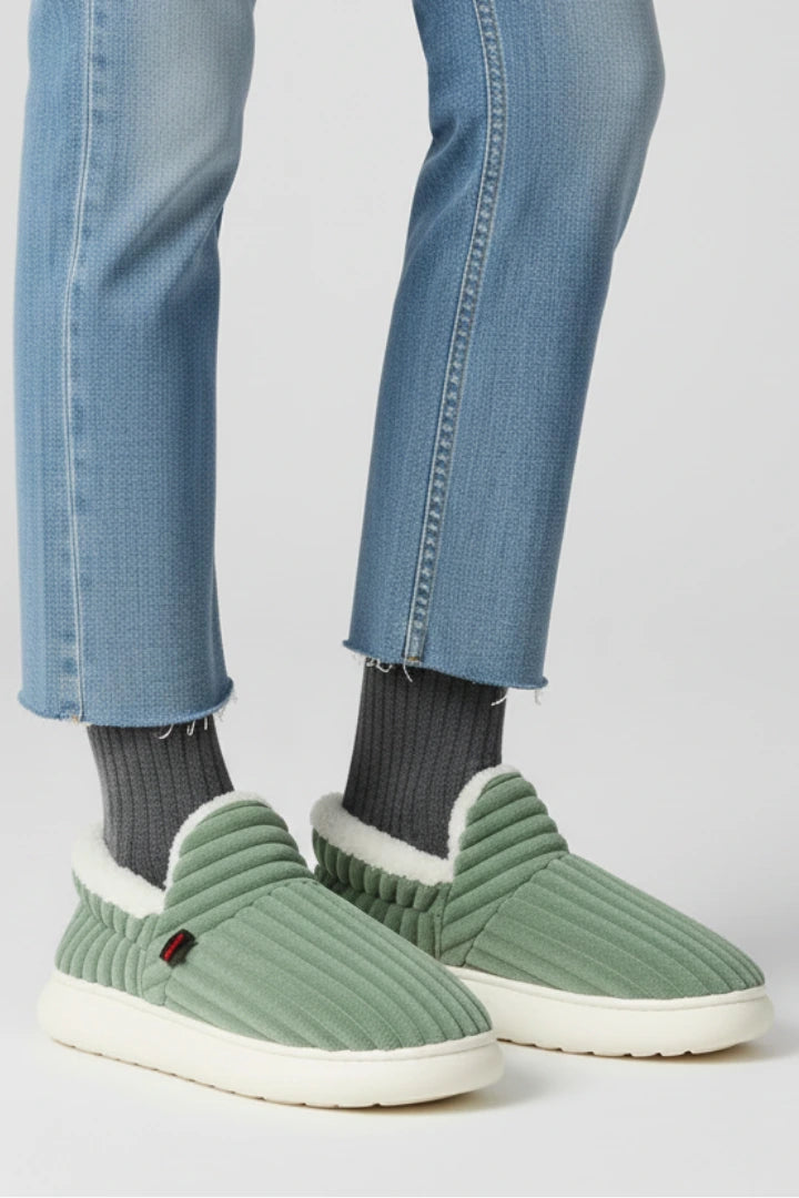 Woman wearing a green ribbed upper faux fur lined slipper - lifestyle photo