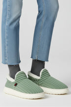Woman wearing a green ribbed upper faux fur lined slipper - lifestyle photo