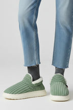 Woman wearing a green ribbed upper faux fur lined slipper - lifestyle photo