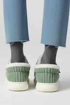 Woman wearing a green ribbed upper faux fur lined slipper - lifestyle photo