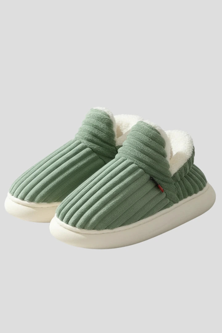 Woman wearing a green ribbed upper faux fur lined slipper - studio photo