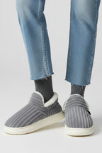 Woman wearing a grey ribbed upper faux fur lined slipper - lifestyle photo