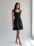 Driftly women's black smocked square-neck sundress, in a minimalist studio setting.