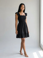 Driftly women's black smocked square-neck sundress, in a minimalist studio setting.