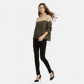 Woman wearing apricot and black colorblock wool turtleneck knit sweater