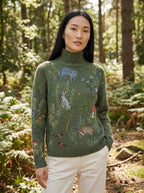 Army green turtleneck sweater with woodland animal print, outdoor forest setting