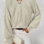 Woman wearing a beige voluminous sleeve sweater with cable knit texture