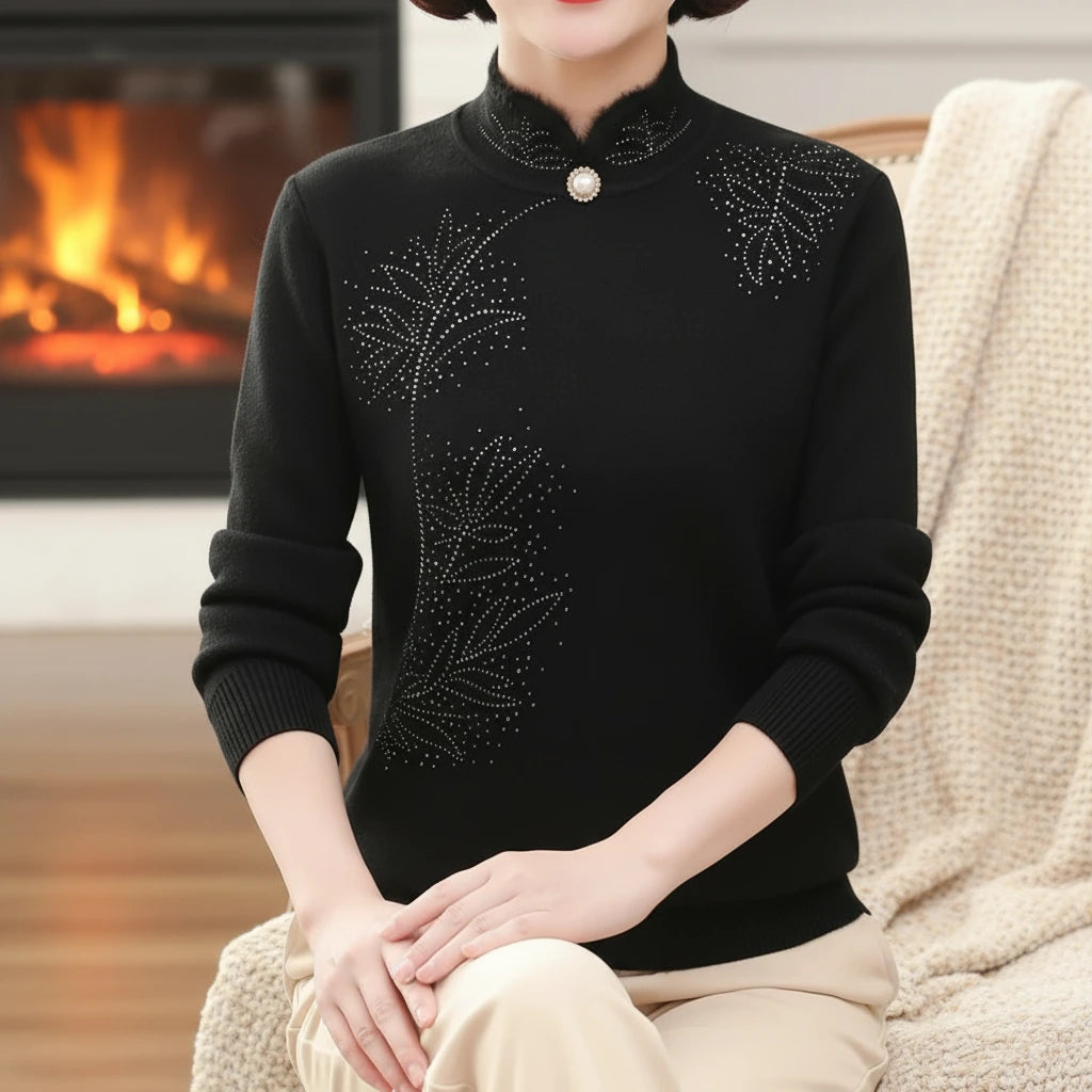 Woman wearing black high-collar sweater with printed button detail by a fireplace