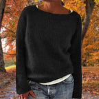 Woman wearing a black merino wool sweater with an autumn background