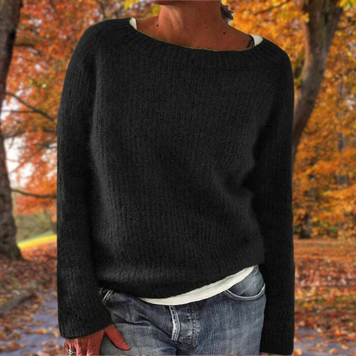 Woman wearing a black merino wool sweater with an autumn background