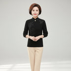 Woman wearing black high-collar sweater with printed button detail, front view