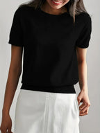Woman wearing a black fine knit sweater with short sleeves, front view