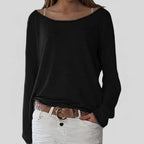 Woman wearing a black lightweight boat neck sweater with relaxed draped fit