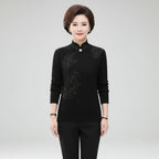 Woman wearing black high-collar sweater with printed button detail, studio photo