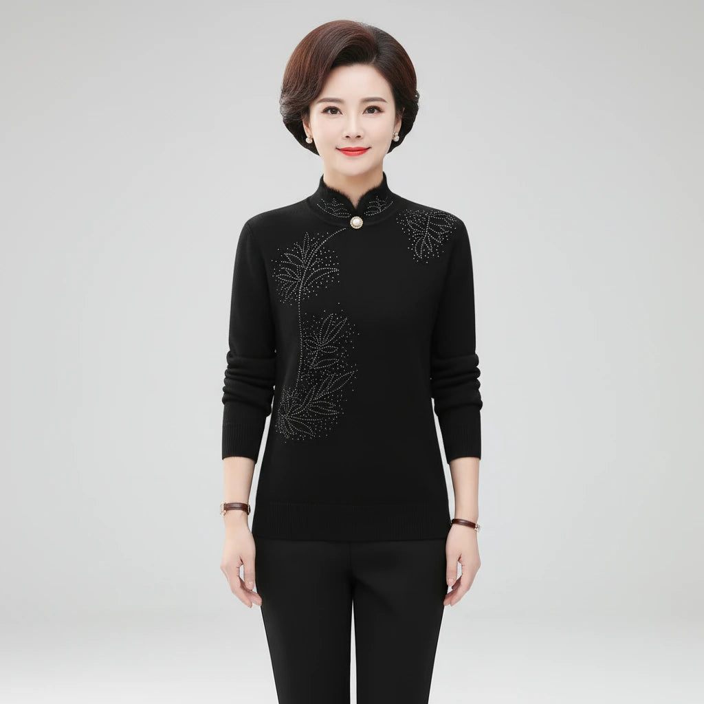 Woman wearing black high-collar sweater with printed button detail, studio photo