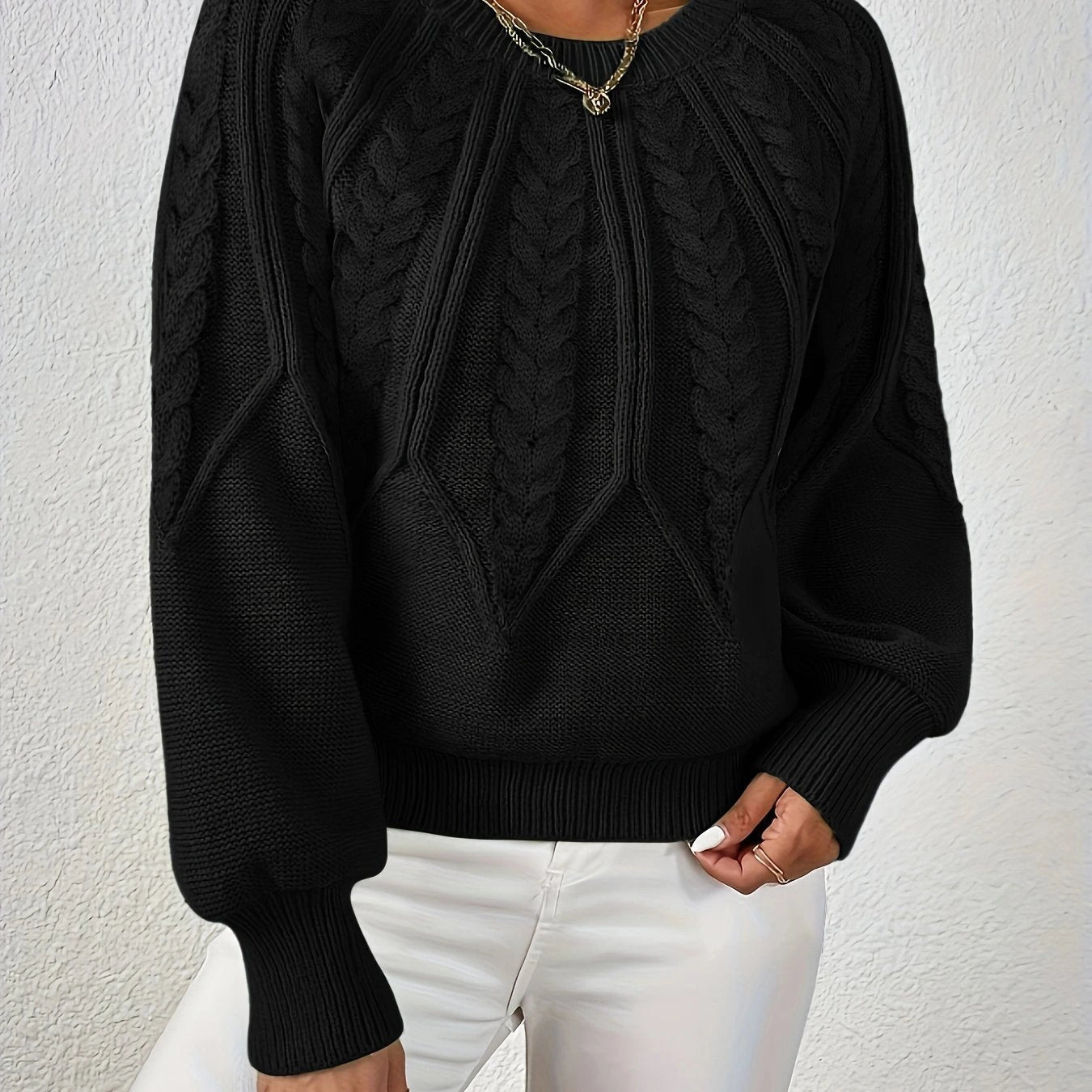 Woman wearing a black voluminous sleeve sweater with cable knit texture