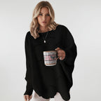 Woman wearing a black oversized open knit sweater with draped asymmetric hem, studio shot