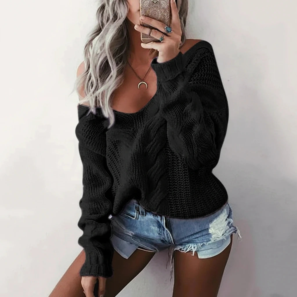Woman wearing black oversized openwork sweater with cable texture, studio photo