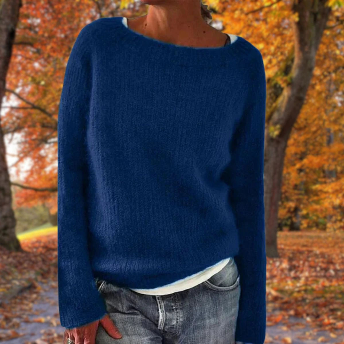 Woman wearing a blue merino wool sweater with an autumn background