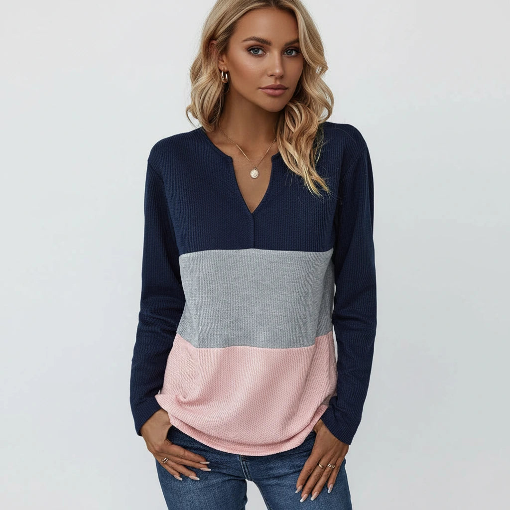 Woman wearing dark blue panelled V-neck sweater, front view