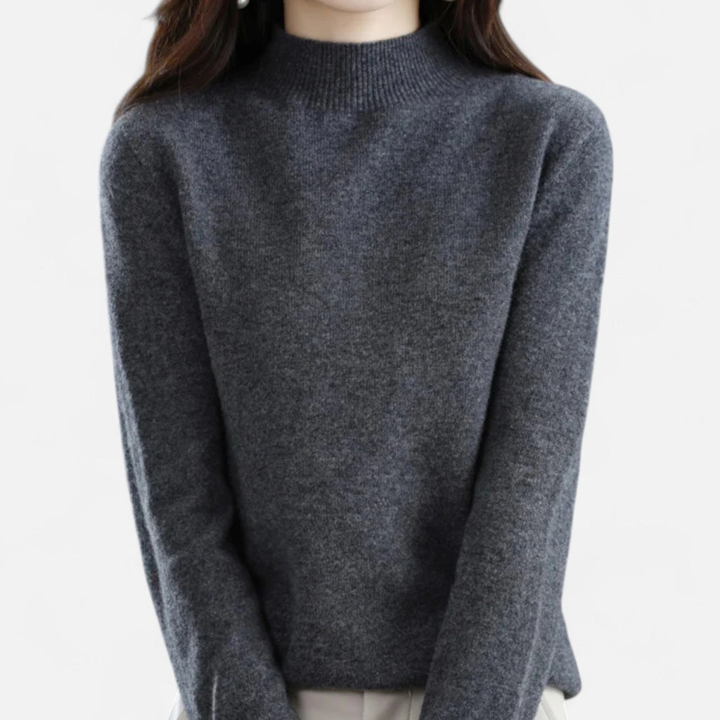Woman wearing a dark grey wool half-neck sweater in a studio setting