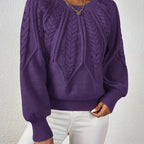 Woman wearing a dark purple voluminous sleeve sweater with cable knit texture