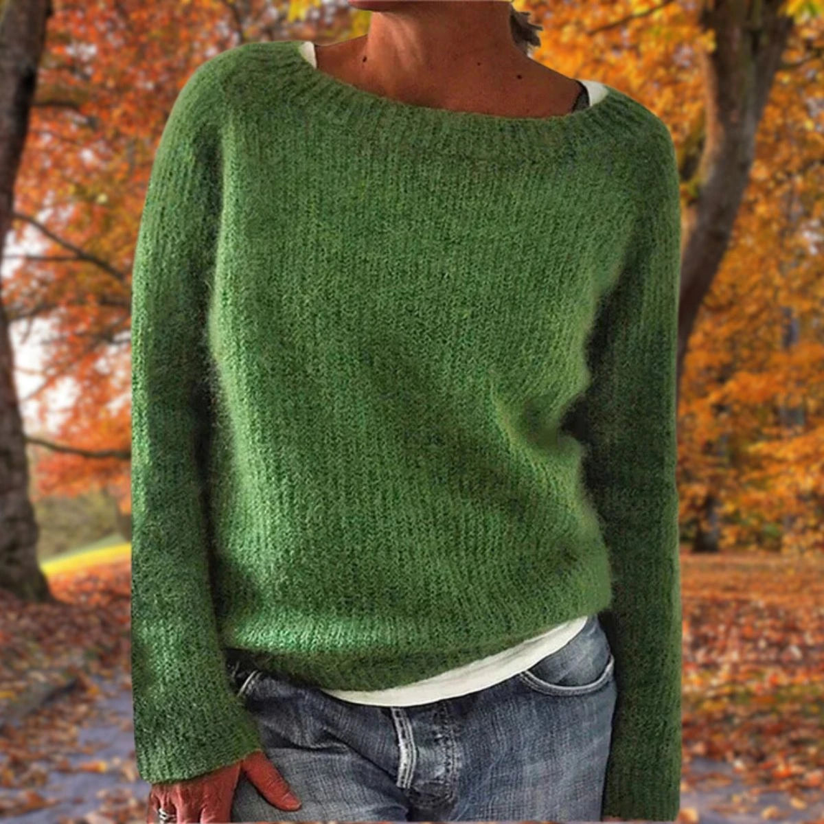 Woman wearing a green merino wool sweater with an autumn background