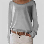 Woman wearing a grey lightweight boat neck sweater with relaxed draped fit