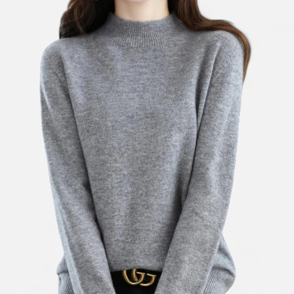 Woman wearing a grey wool half-neck sweater in a studio setting