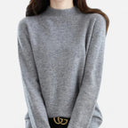 Woman wearing a grey wool half-neck sweater in a studio setting