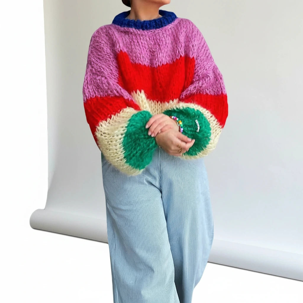 Woman wearing a hot pink striped chunky knit sweater with balloon sleeves, studio shot