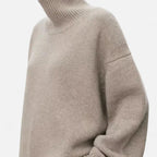 Woman wearing a khaki oversized wool turtleneck sweater in a studio setting