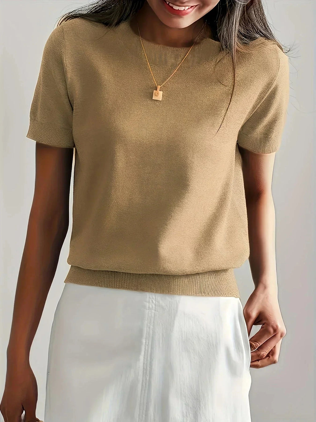 Woman wearing a khaki fine knit sweater with short sleeves, side view