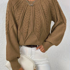 Woman wearing a khaki voluminous sleeve sweater with cable knit texture