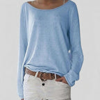 Woman wearing a light blue lightweight boat neck sweater with relaxed draped fit