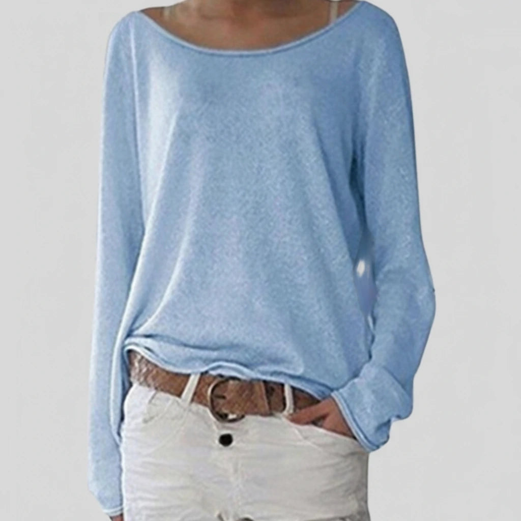 Woman wearing a light blue lightweight boat neck sweater with relaxed draped fit